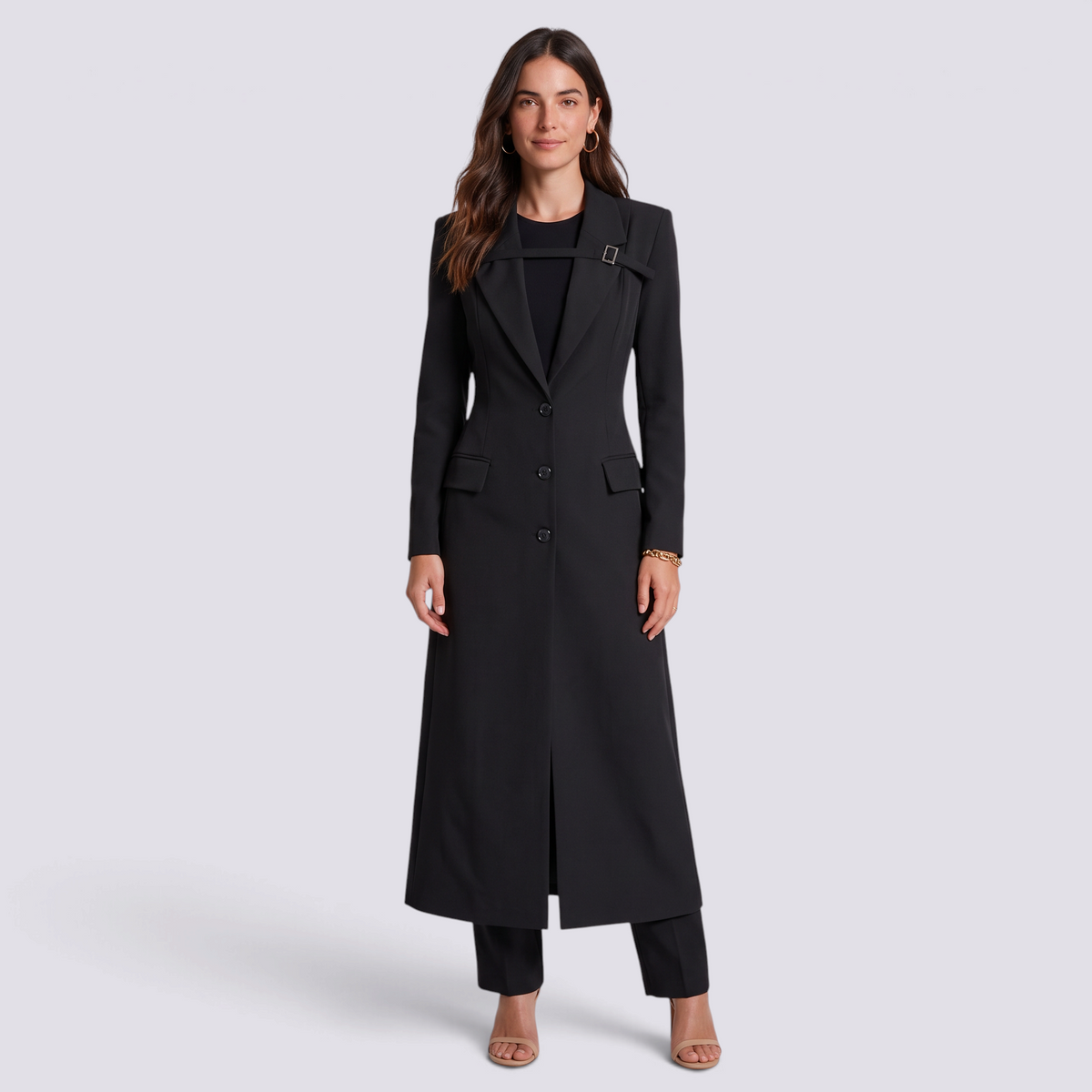 Mujer con blazer largo negro entallado con hebilla, vista frontal