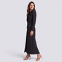 Mujer con blazer largo negro entallado con hebilla, vista lateral