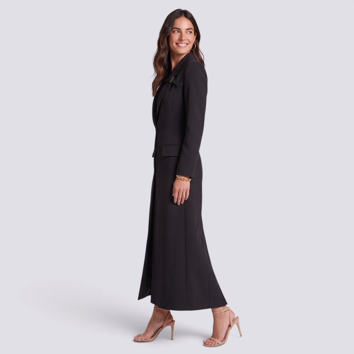 Mujer con blazer largo negro entallado con hebilla, vista lateral