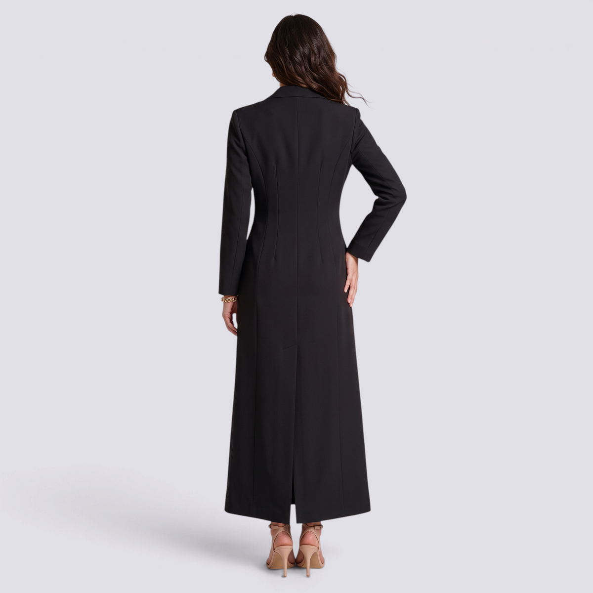 Mujer con blazer largo negro entallado con hebilla, vista trasera