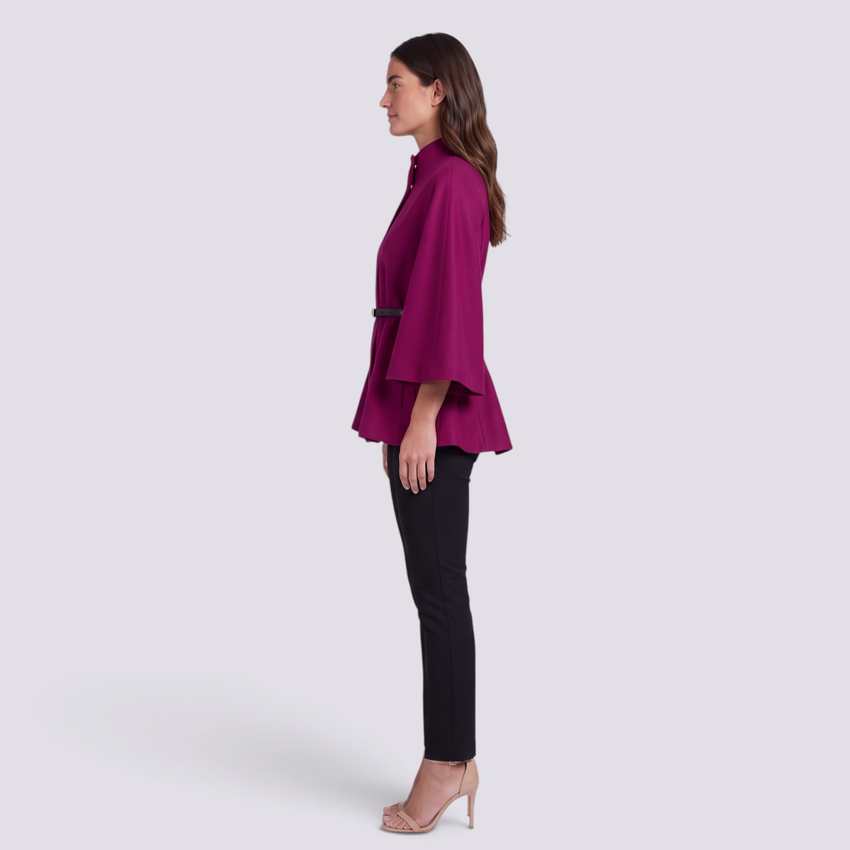 Mujer con capa de manga murciélago y cinturón fino en fucsia, vista lateral