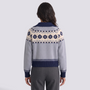 Mujer con chaqueta de punto con cremallera y greca jacquard en gris y azul marino, vista trasera