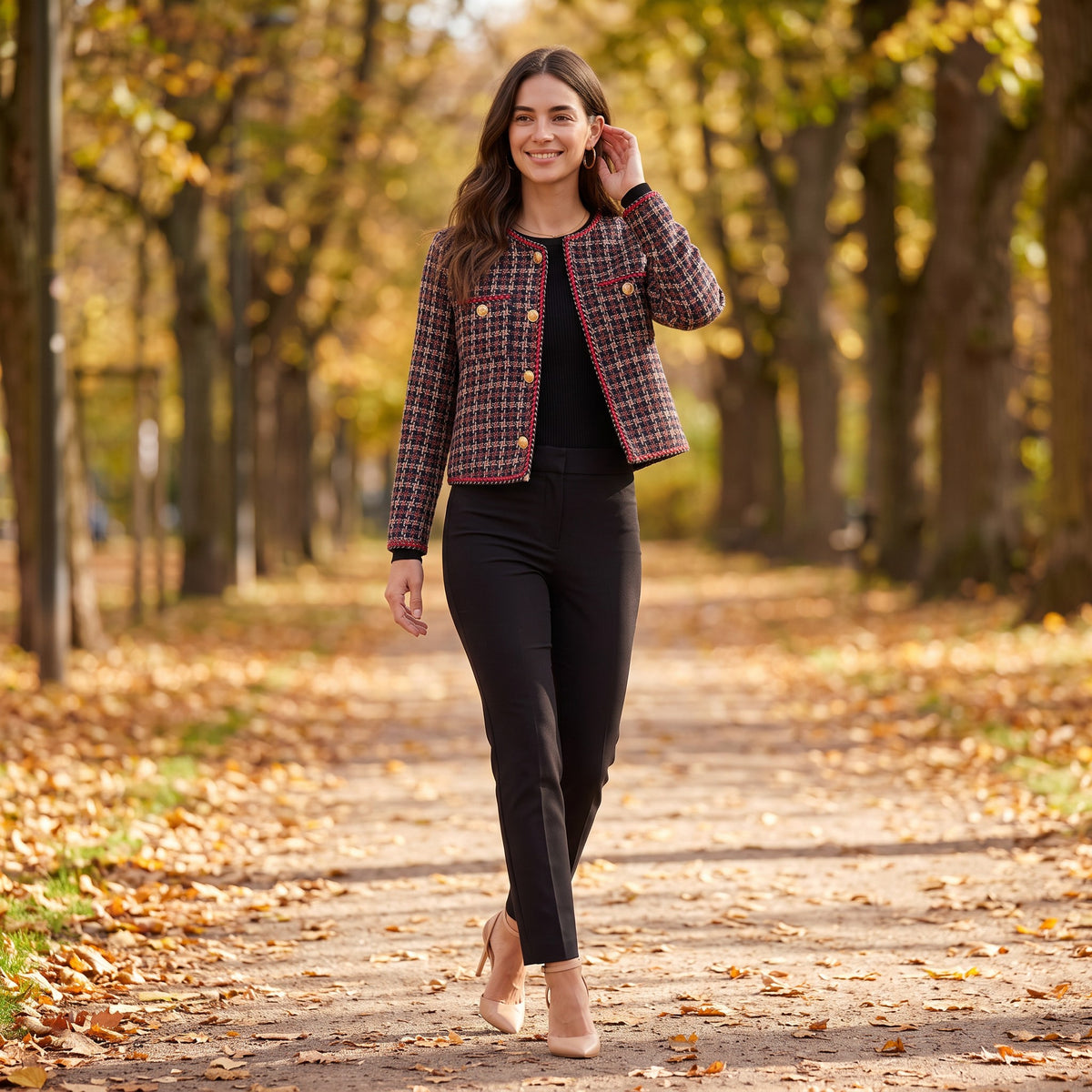 Mujer paseando por un parque en otoño con una chaqueta corta de botones dorados