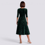 Essyro midi dress in dark green velvet with floral jacquard pattern, long sleeves, and A-line skirt, back view.