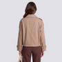 Back view of a woman wearing an Essyro beige cropped double-breasted trench jacket with epaulettes and belted cuffs.
