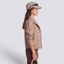 Essyro beige double-breasted cropped trench jacket worn by a woman with a matching cap in a side profile view.