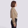 Essyro beige cropped windbreaker jacket with long sleeves and button details worn by a woman in profile view