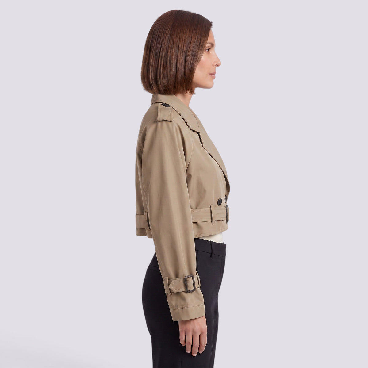 Essyro beige cropped windbreaker jacket with long sleeves and button details worn by a woman in profile view