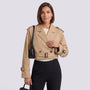 Essyro beige cropped windbreaker jacket worn by a woman with a black shoulder bag and trousers