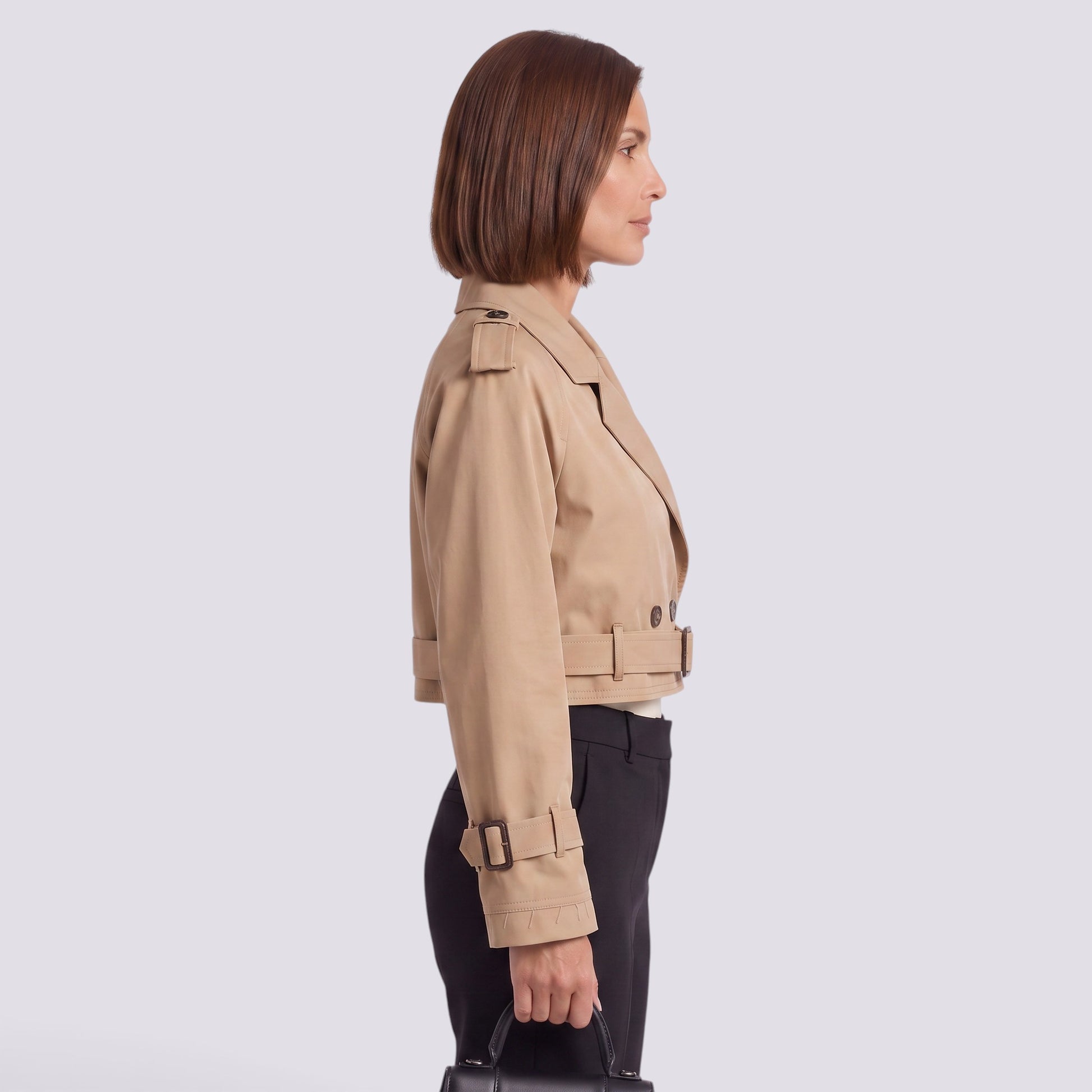 Essyro beige cropped windbreaker jacket with epaulettes and belted waist worn by a woman in profile view