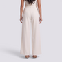 Essyro beige high-waisted wide-leg tailored trousers seen from the back on a model wearing heels