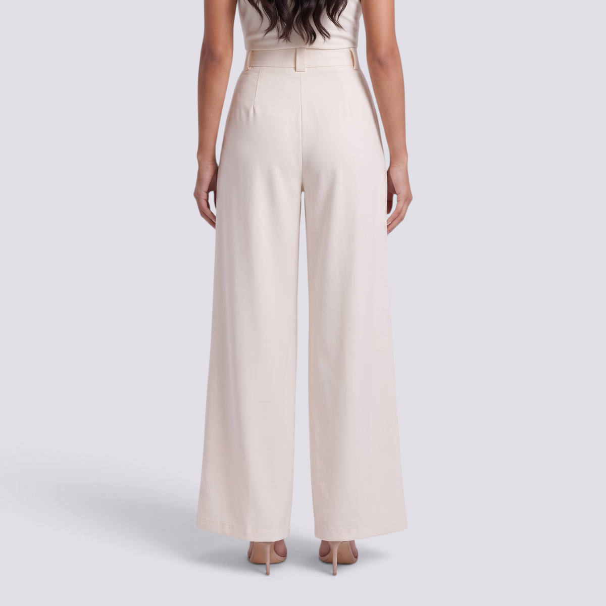 Essyro beige high-waisted wide-leg tailored trousers seen from the back on a model wearing heels
