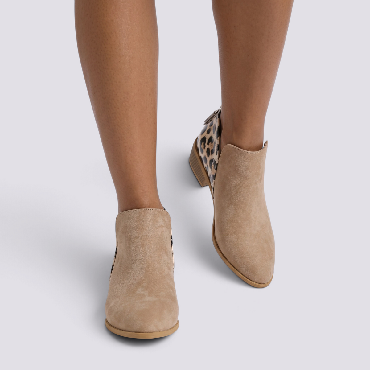 Essyro beige suede ankle boots with leopard print heel, almond toe, and low block heel worn by a model.