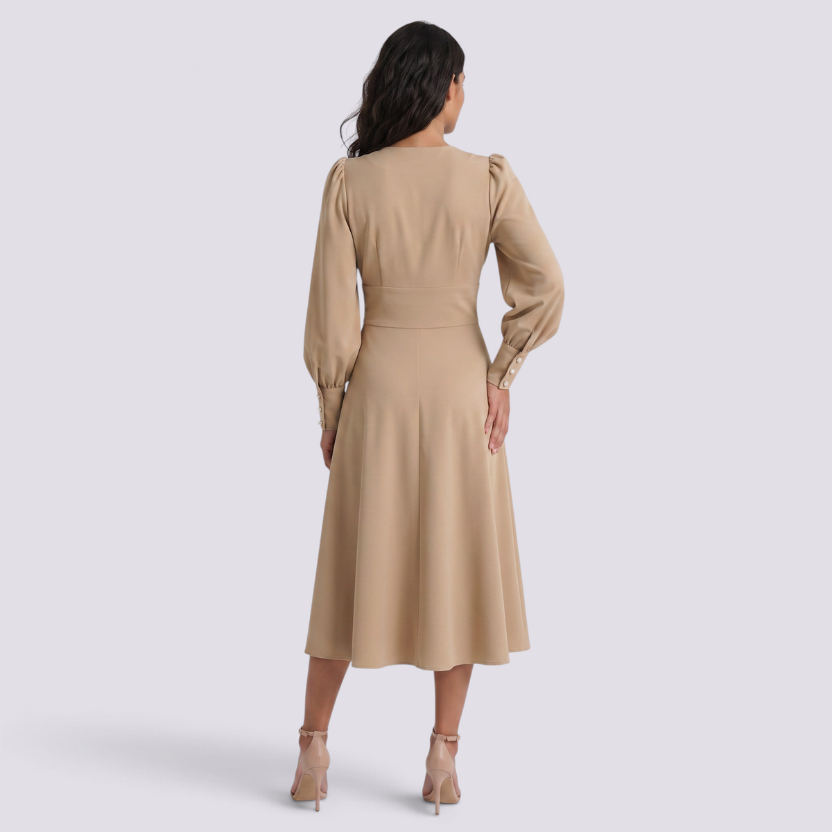 Essyro beige midi dress with puff sleeves and buttoned cuffs, viewed from the back on a model wearing heels.