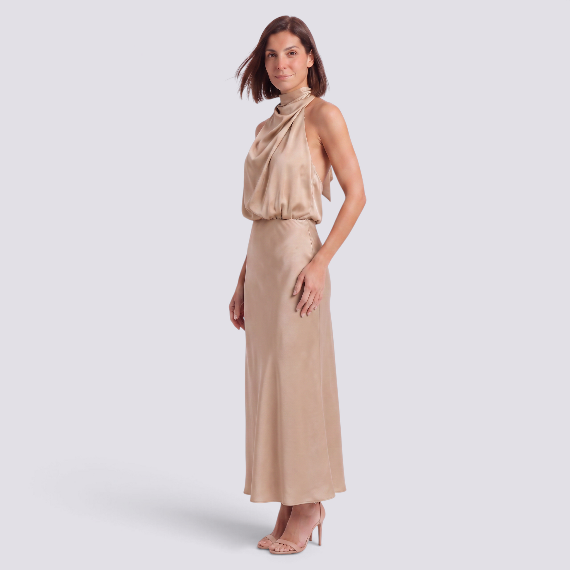 Essyro beige satin halter neck maxi dress with draped bodice and open back worn by a woman in studio