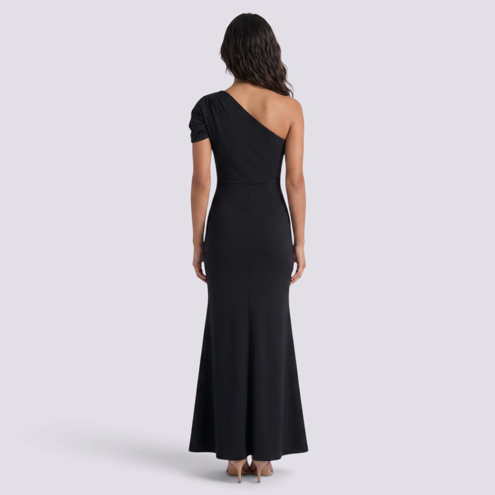 Essyro black floor-length mermaid gown with an asymmetrical one-shoulder neckline and draped sleeve, back view.