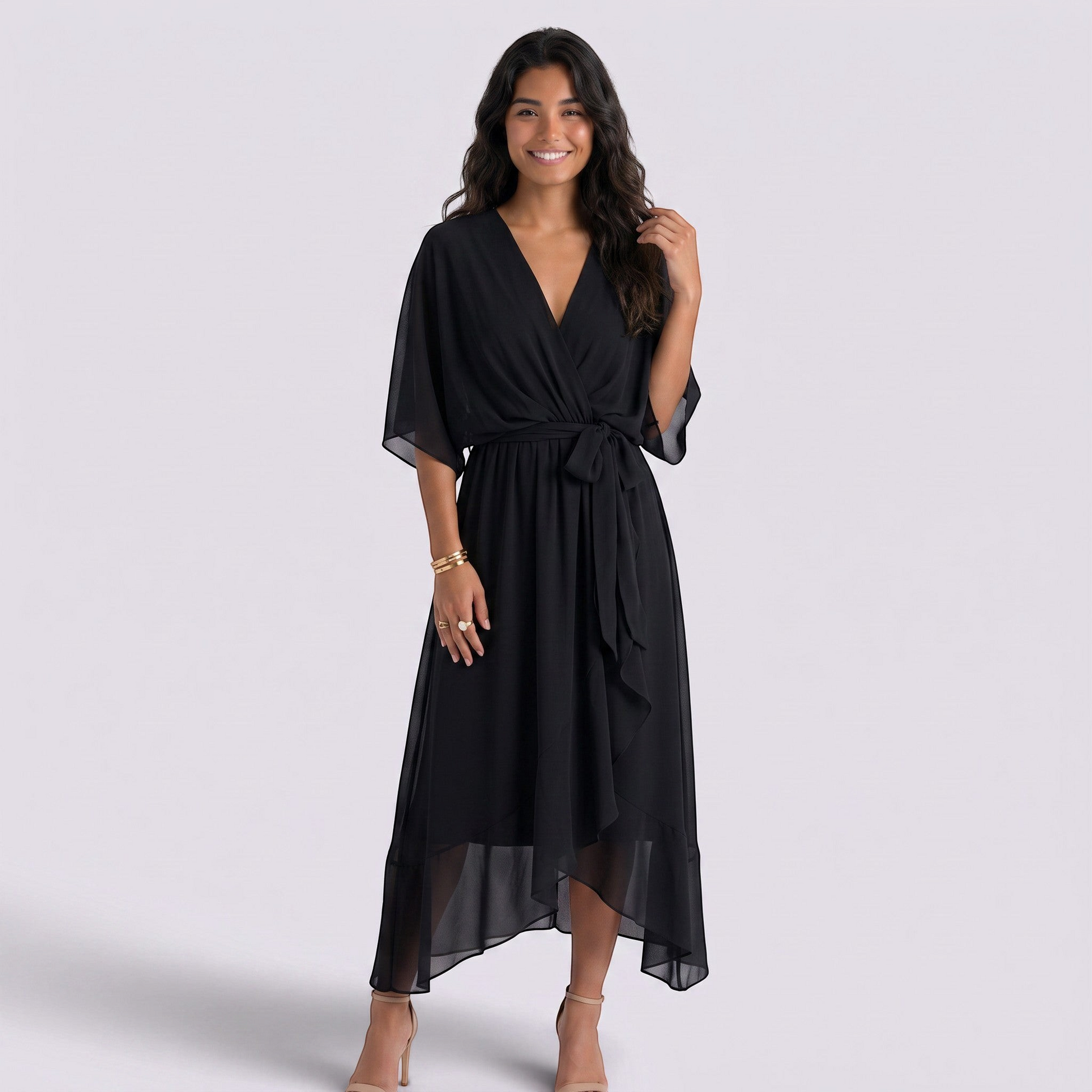 Essyro black midi dress with V-neck, batwing sleeves, and a tie-waist, worn by a smiling woman in heels.