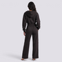 Back view of a woman wearing an Essyro black cropped hoodie and matching wide-leg trousers with visible seam details.