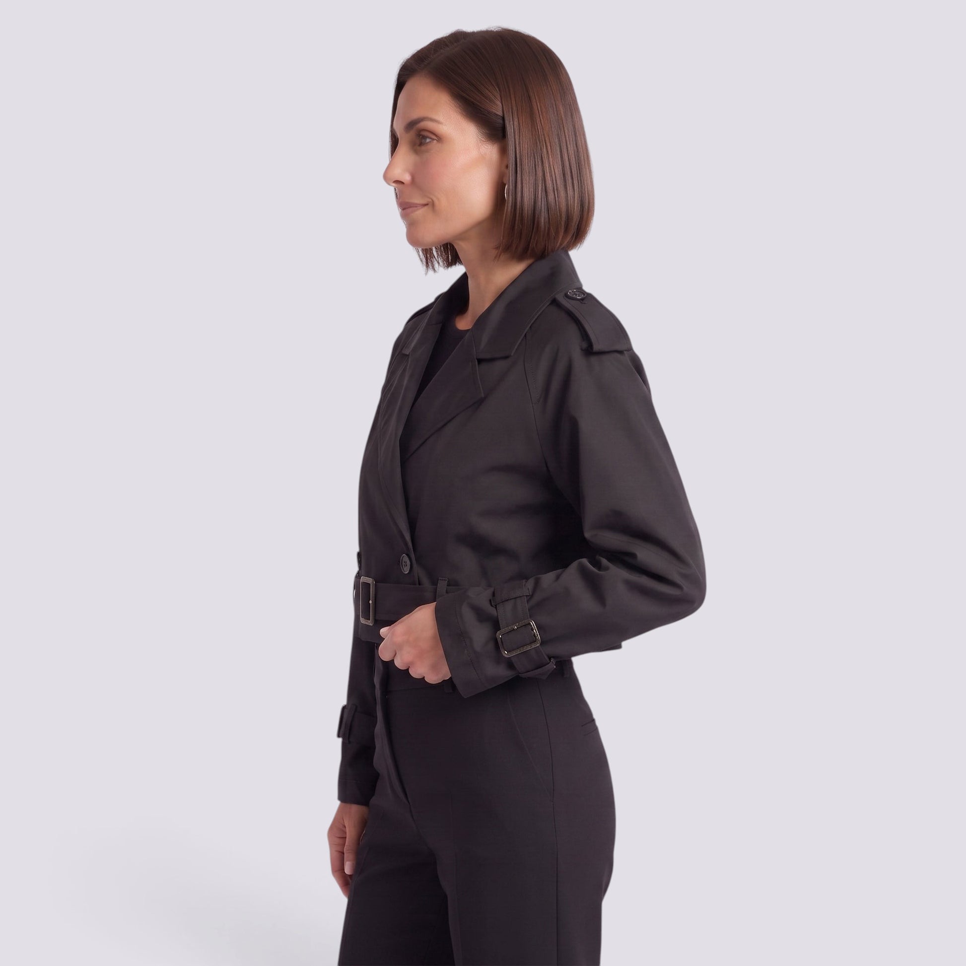 Essyro black cropped windbreaker jacket with belted waist and long sleeves worn by a woman in a side profile view.