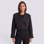 Essyro black cropped windbreaker jacket with trench-style lapels, belted waist, and buckle cuffs on a female model.