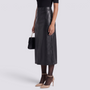 Essyro black faux leather midi skirt with high waist, front slit, and side pockets worn with heels and a handbag