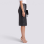 Essyro high-waisted black faux leather pencil skirt with a back slit, worn by a model with nude heels.