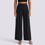 Essyro high-waisted black palazzo trousers with wide legs and front pleats worn with a black crop top