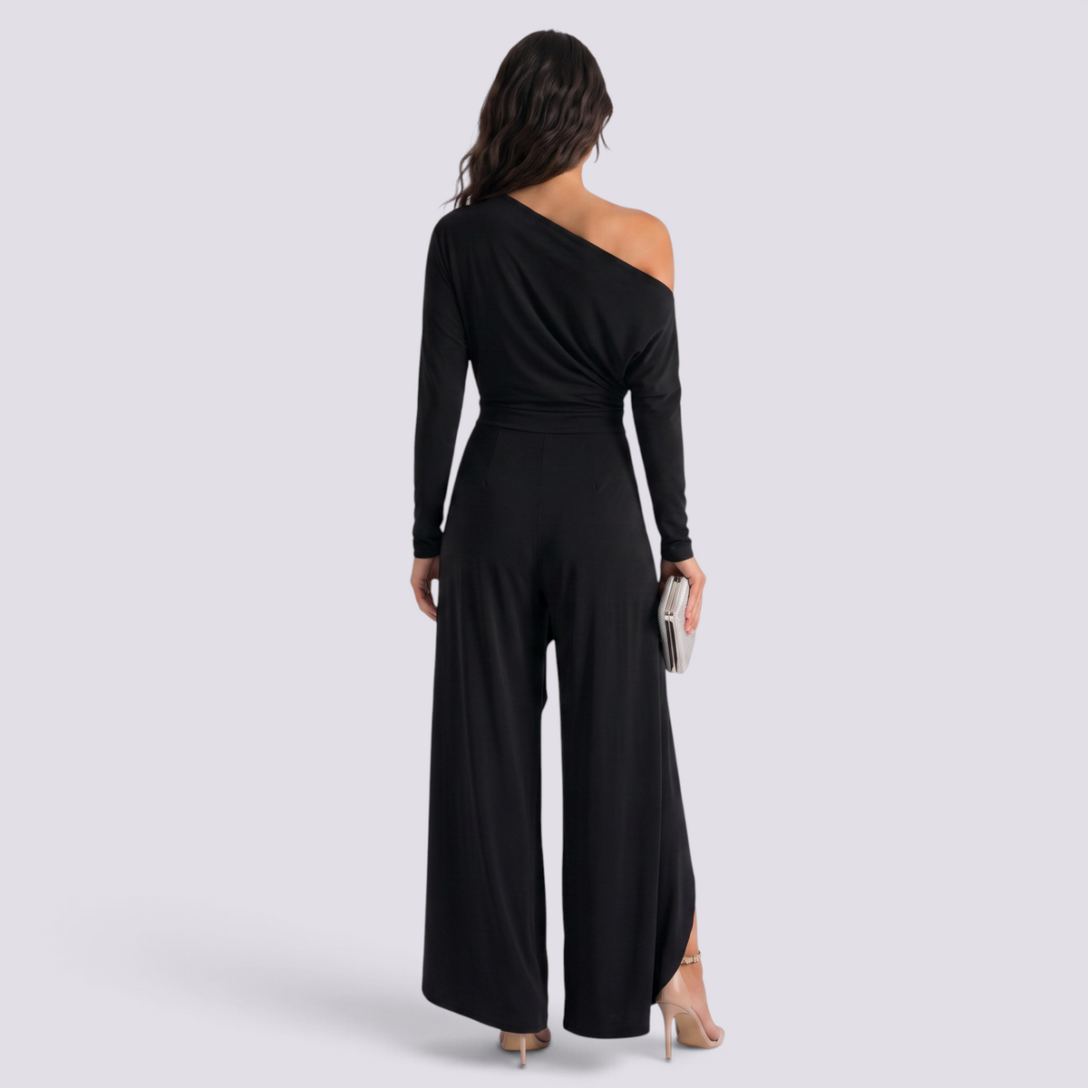 Essyro black one-shoulder jumpsuit with long draped sleeve and wide-leg trousers, back view on a model.