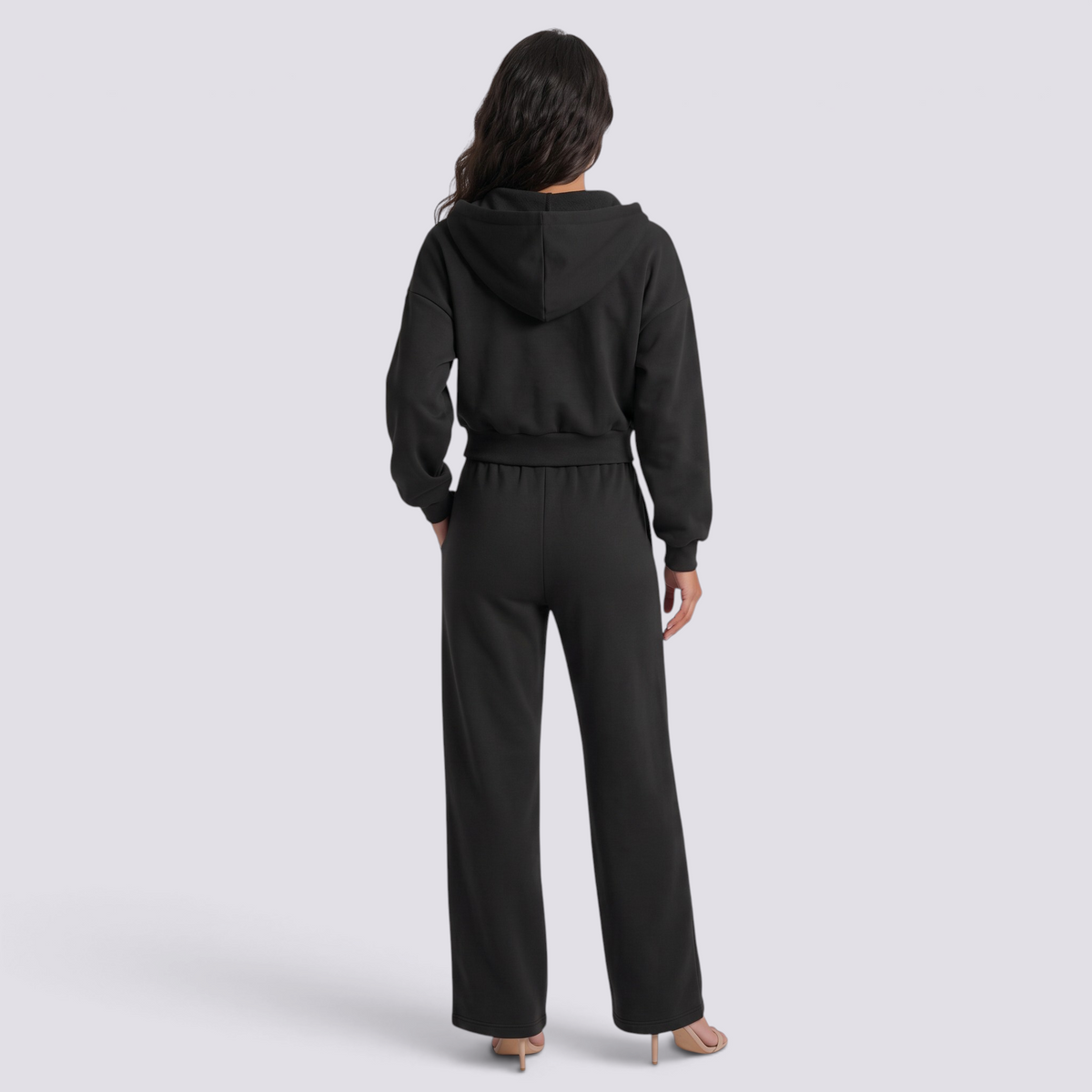 Essyro black oversized hoodie and wide-leg trousers set worn by a woman, back view showing a relaxed fit.