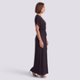 Essyro elegant black plus size maxi dress with short sleeves and a belted waist worn by a model in profile view