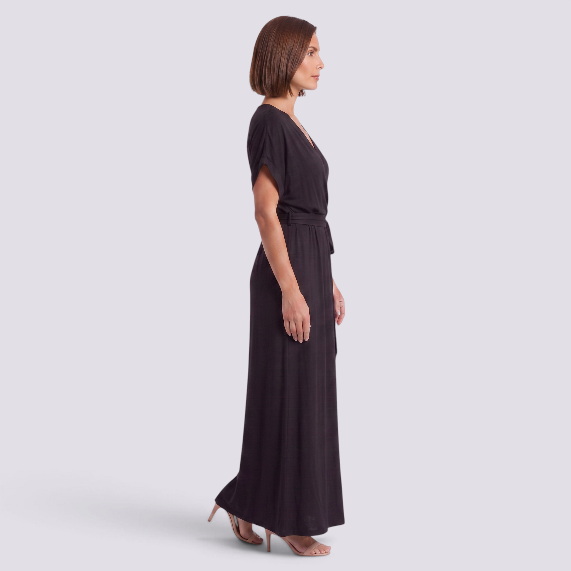 Essyro elegant black plus size maxi dress with short sleeves and a belted waist worn by a model in profile view