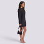 Essyro black ribbed knit oversized mini hoodie dress with long sleeves worn by a model in profile view