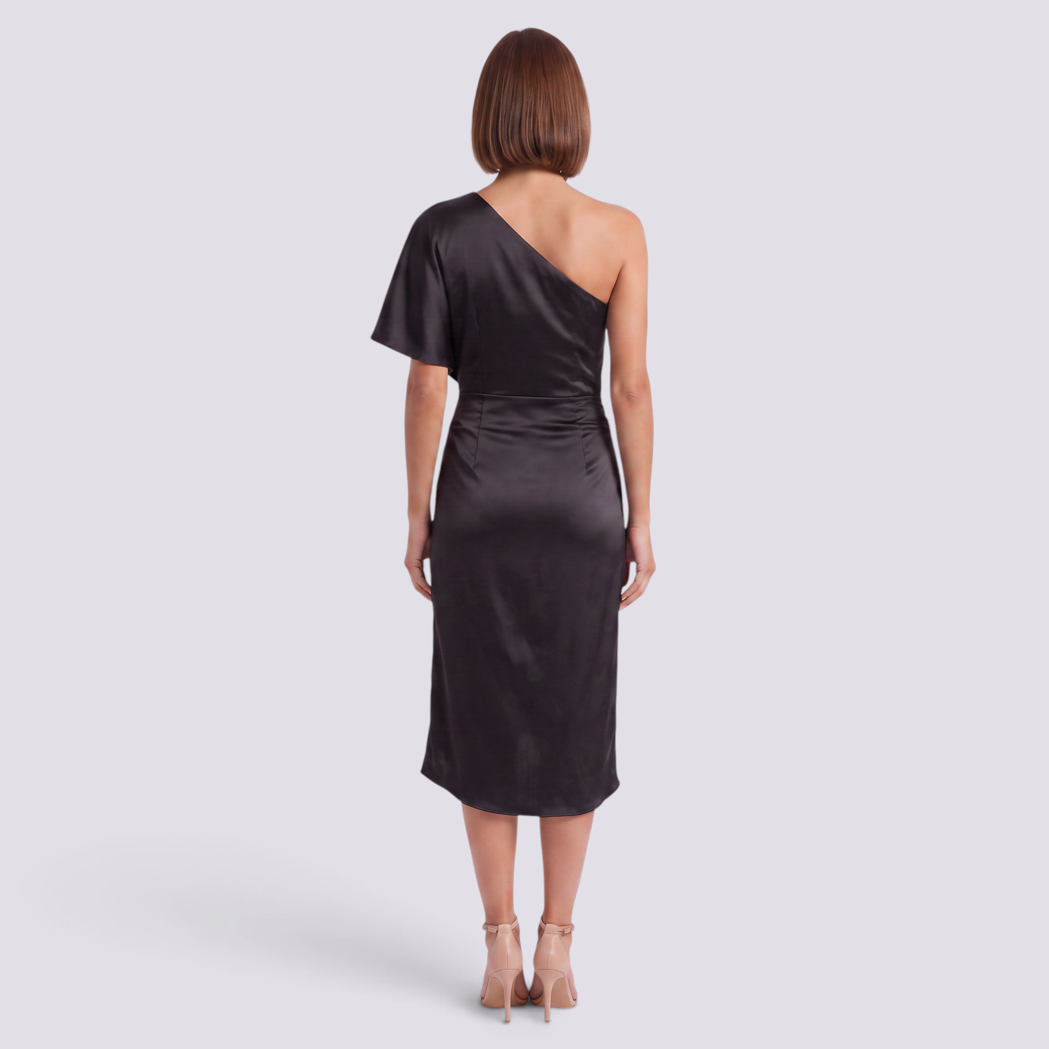 Back view of a woman wearing an Essyro black satin one-shoulder midi dress with an asymmetrical hem and heels.