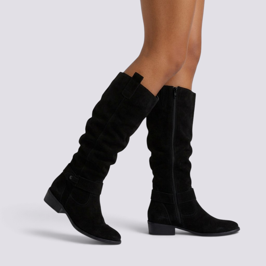 Essyro black knee-high slouch boots with low block heel, suede-effect finish, and decorative ankle strap with rivet.