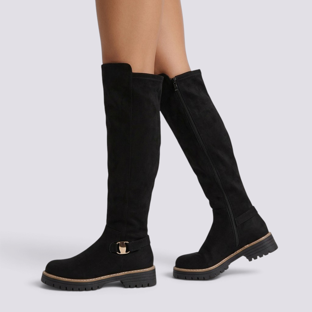Essyro black knee-high suede boots with gold buckle detail and chunky track sole on a model
