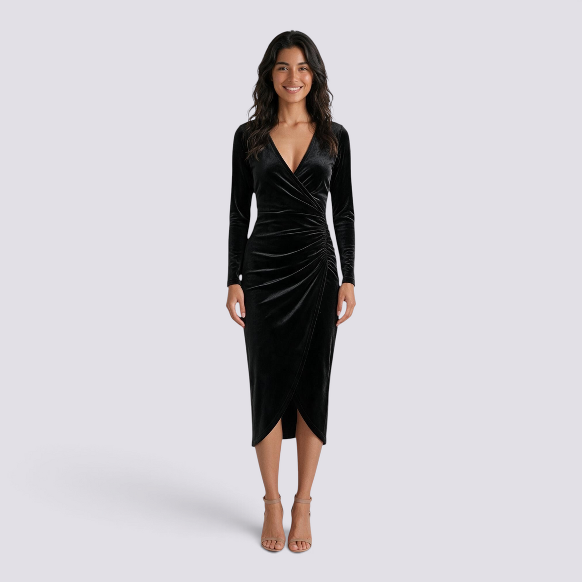 Essyro black velvet midi dress with long sleeves, V-neck, draped waist, and asymmetric hem worn by a smiling model.