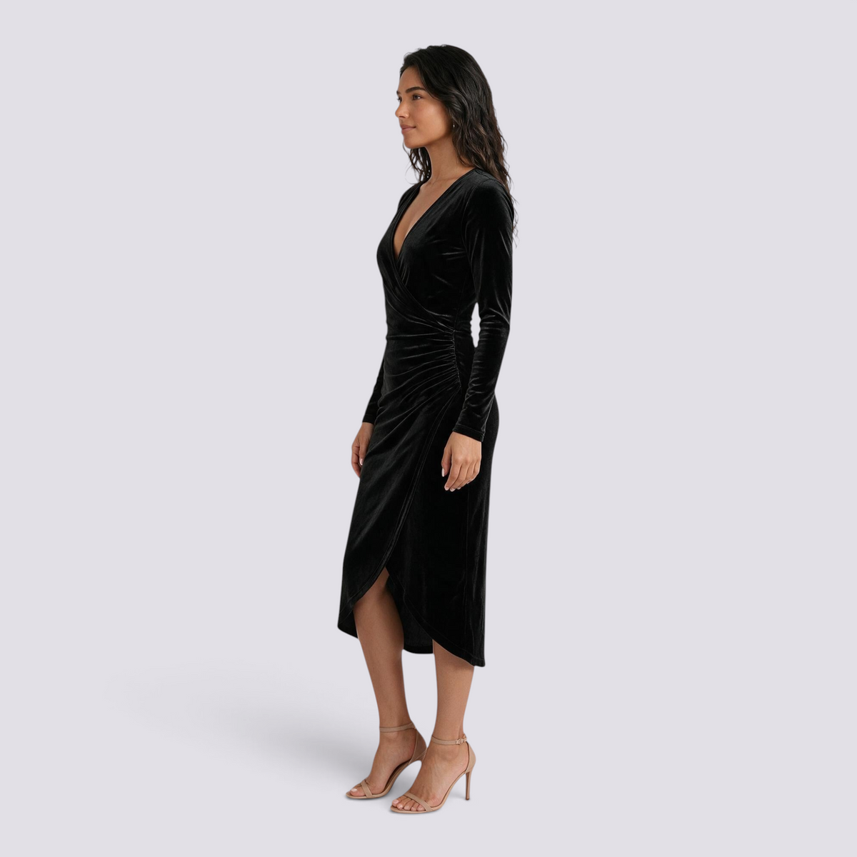 Essyro black velvet midi dress with a wrap V-neck, long sleeves, and an asymmetrical side-slit hem on a model.
