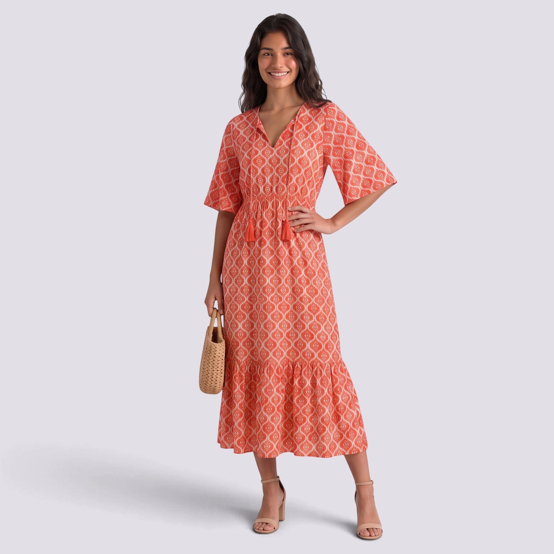 Essyro bohemian long dress in coral with white geometric print, V-neck, short sleeves, and tassel tie detail.