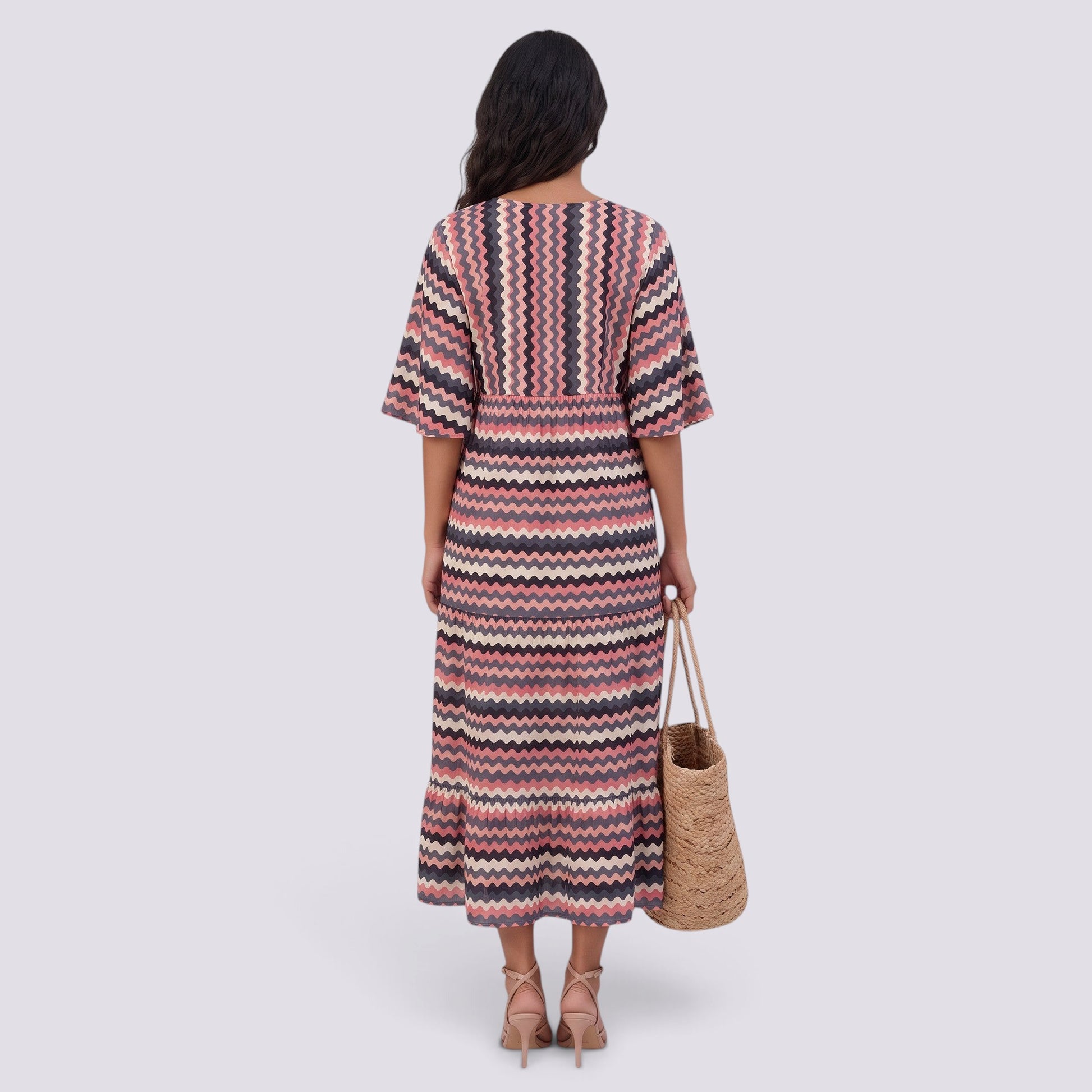 Essyro bohemian maxi dress with V-neck, short sleeves, and pink and black chevron pattern, back view on a model.
