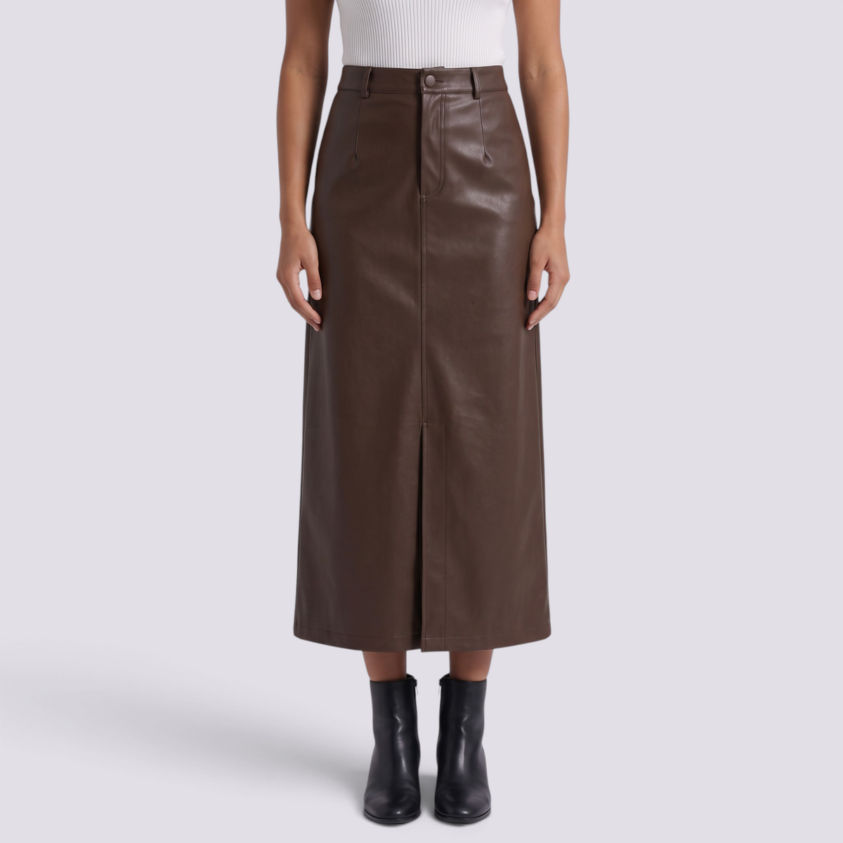 Essyro brown faux leather midi skirt with high waist, front slit, and button closure worn by a model