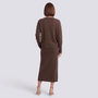 Essyro brown knit two-piece set with a loose sweater and midi skirt, shown from the back on a woman in heels.