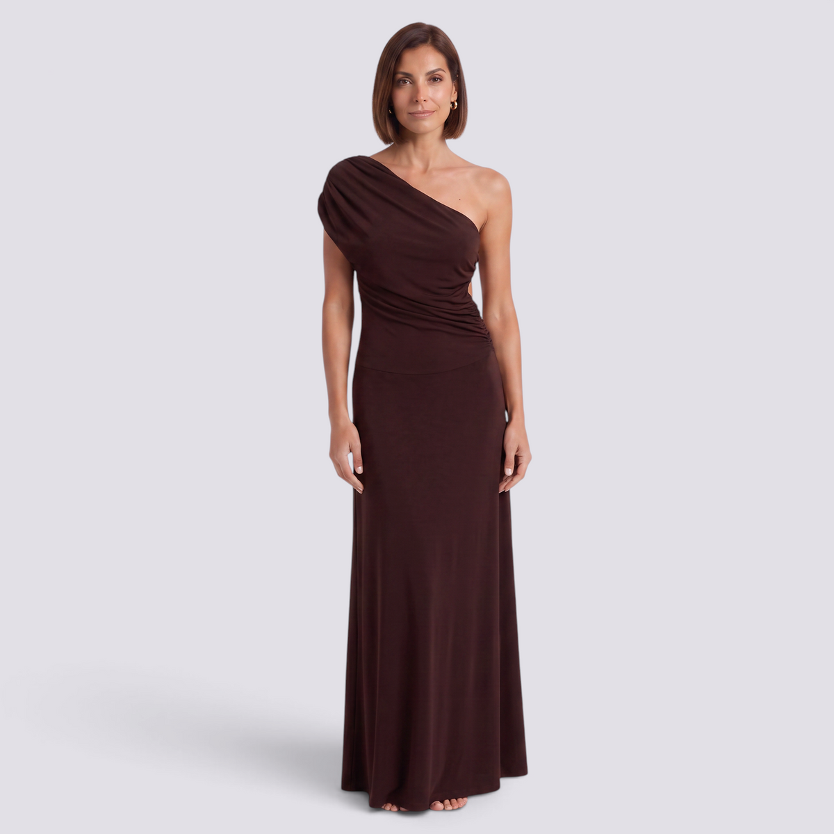 Essyro brown one-shoulder maxi dress with draped sleeve, gathered waist, and column skirt on a model