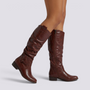 Essyro brown knee-high slouch boots with low block heel, side zipper, and decorative ankle strap with metal rivet