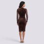Back view of an Essyro brown velvet midi sheath dress with long lace sleeves and scalloped lace hem on a model
