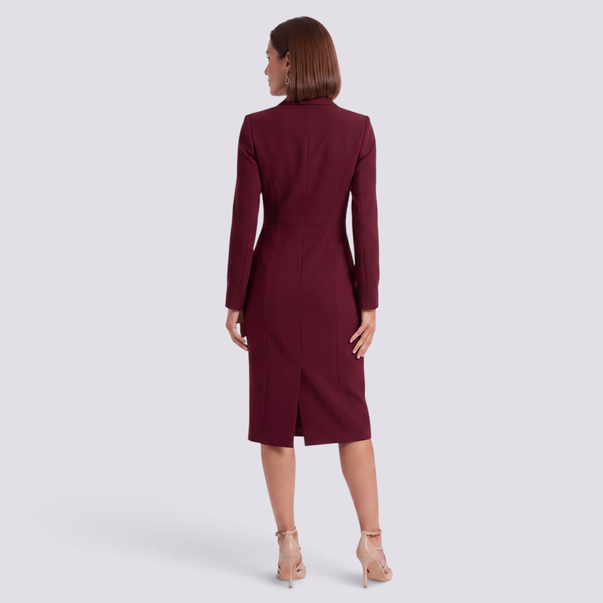 Back view of a woman wearing an Essyro burgundy tailored blazer dress with long sleeves and a back slit