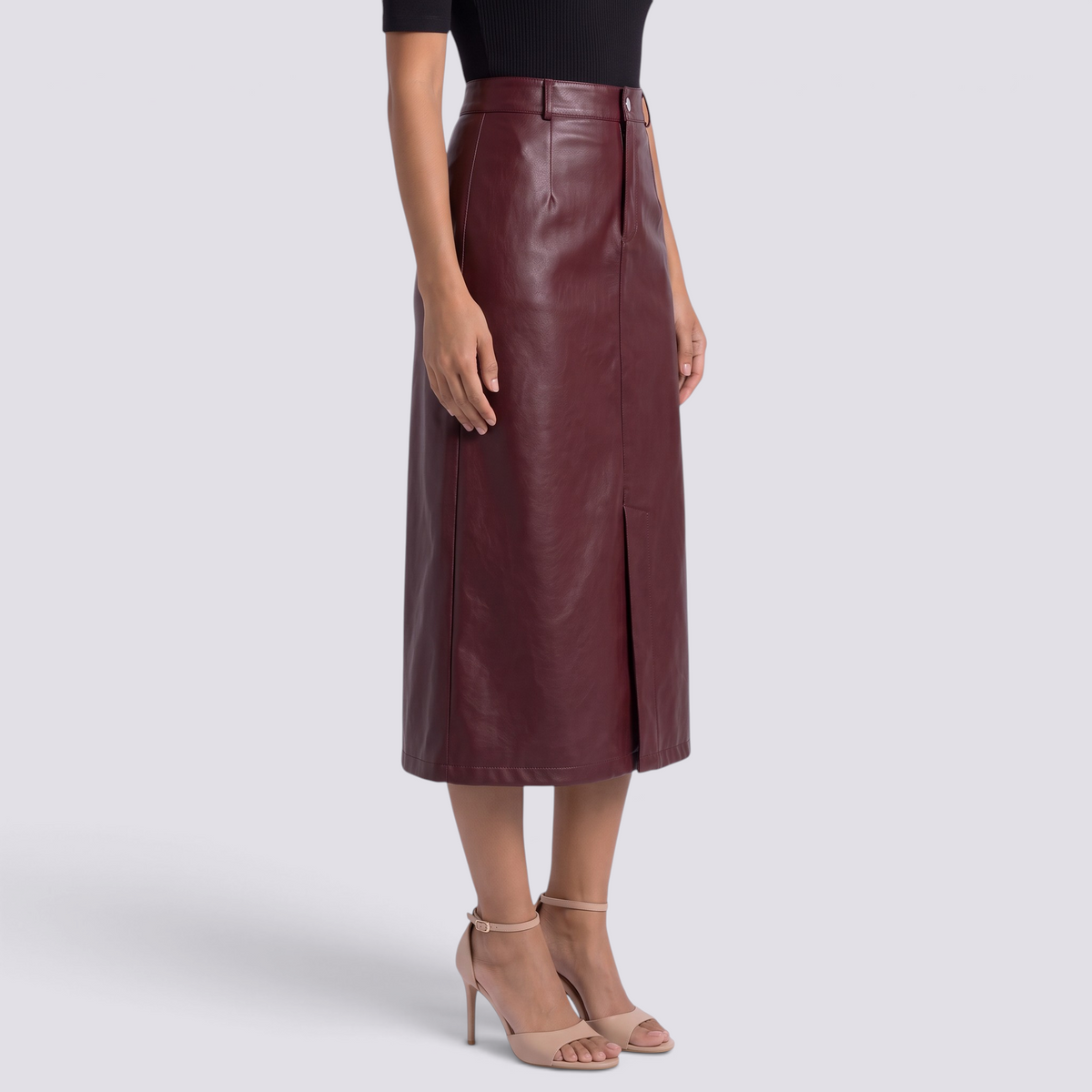 Essyro burgundy faux leather midi skirt with high waist, front slit, and side pockets worn with beige heels.