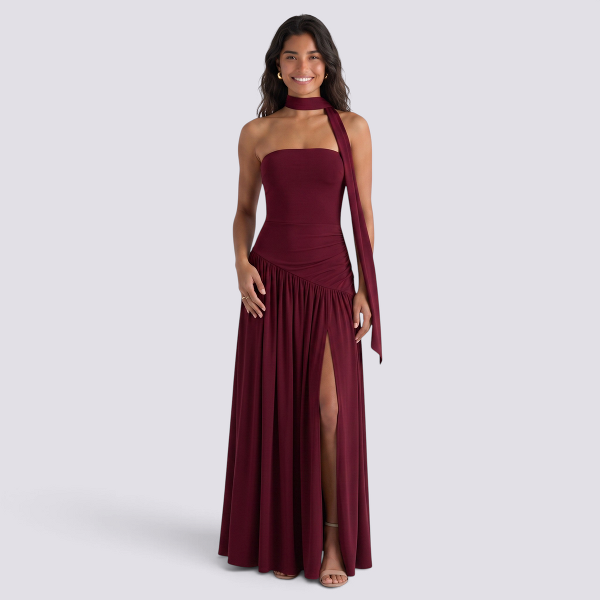 Essyro burgundy floor-length party dress with halter neck, draped asymmetric skirt, and high side slit on a model.