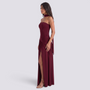Essyro burgundy floor-length evening dress with halter neck, draped asymmetric skirt, and side slit on a model