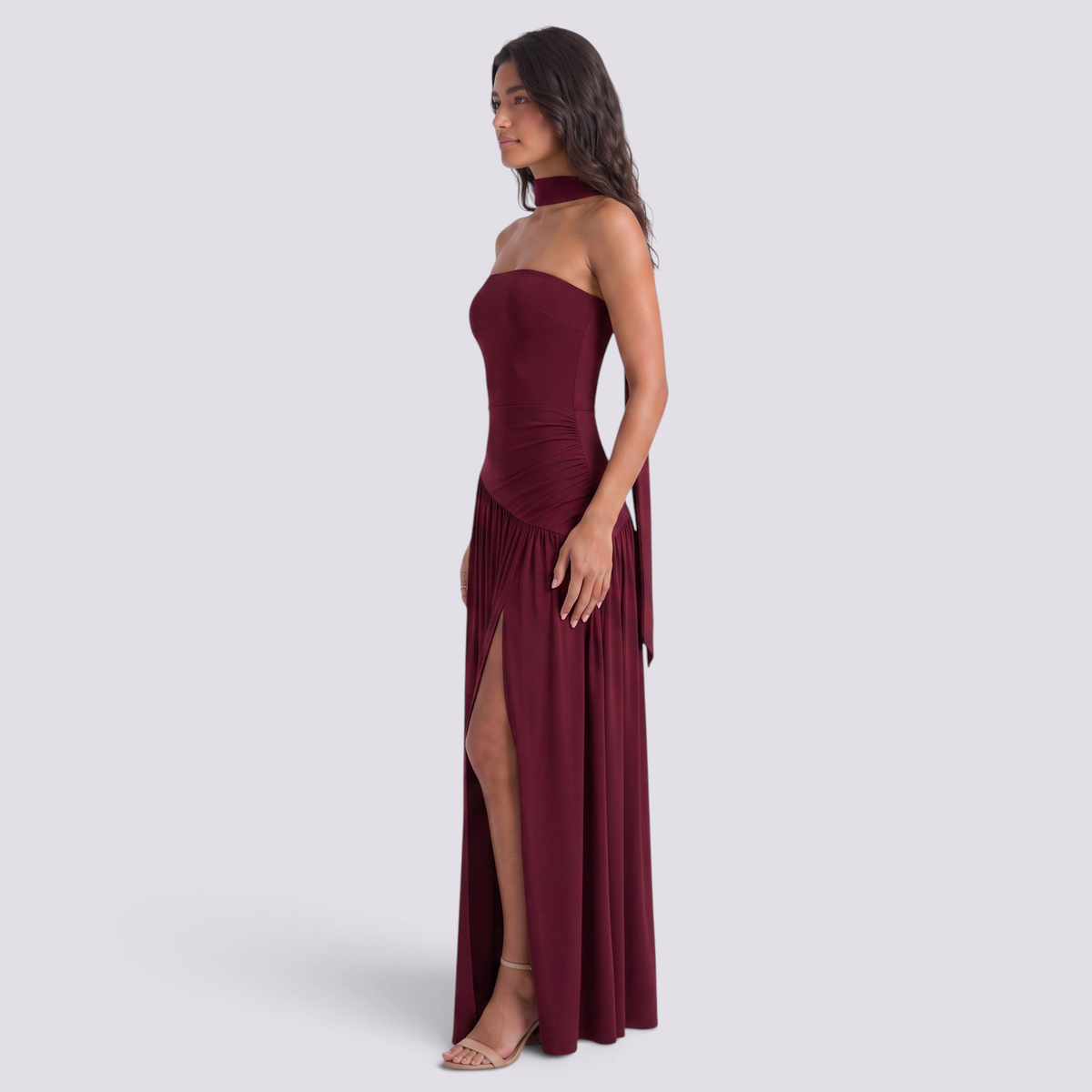 Essyro burgundy floor-length evening dress with halter neck, draped asymmetric skirt, and side slit on a model