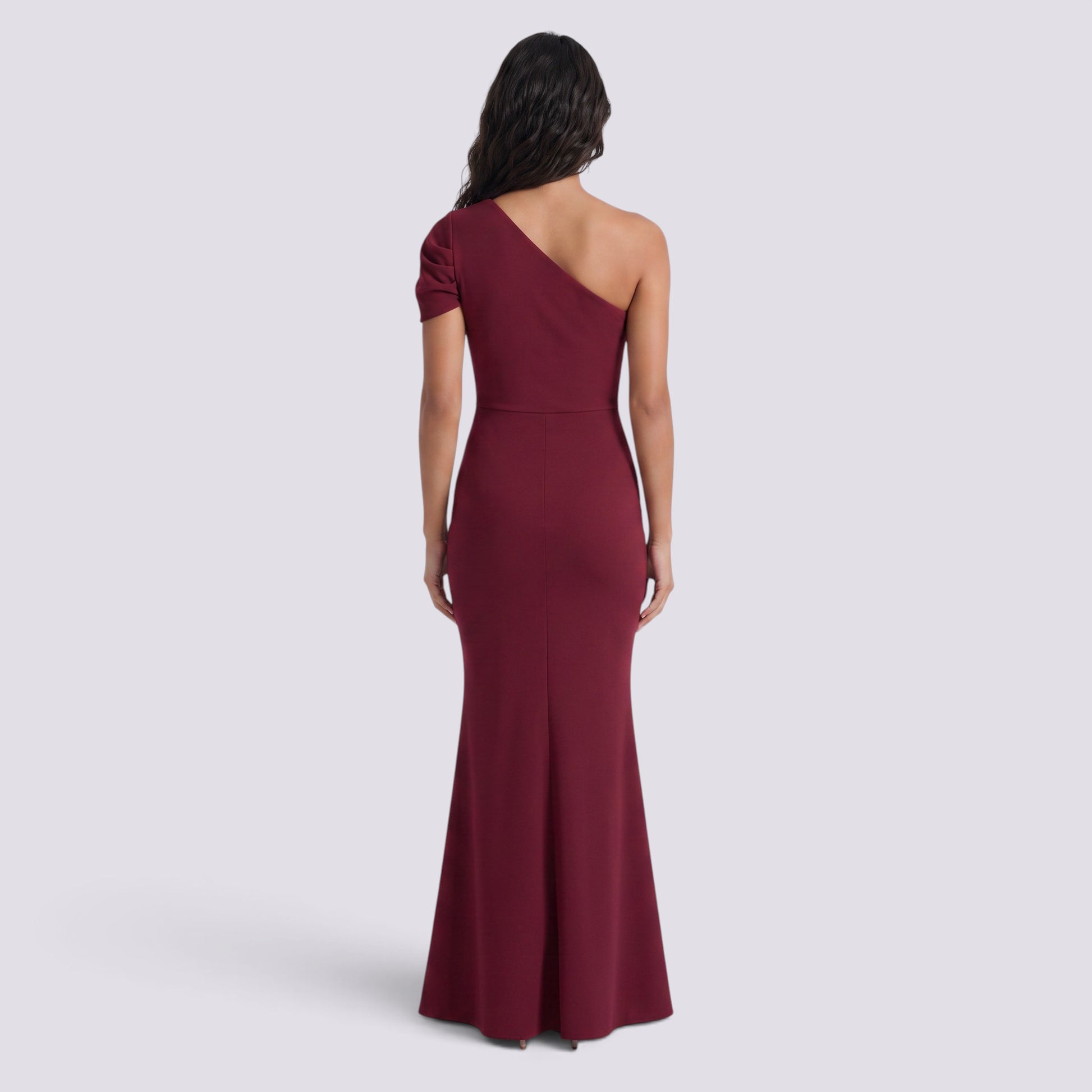 Back view of an Essyro burgundy floor-length mermaid gown with an asymmetrical one-shoulder design.
